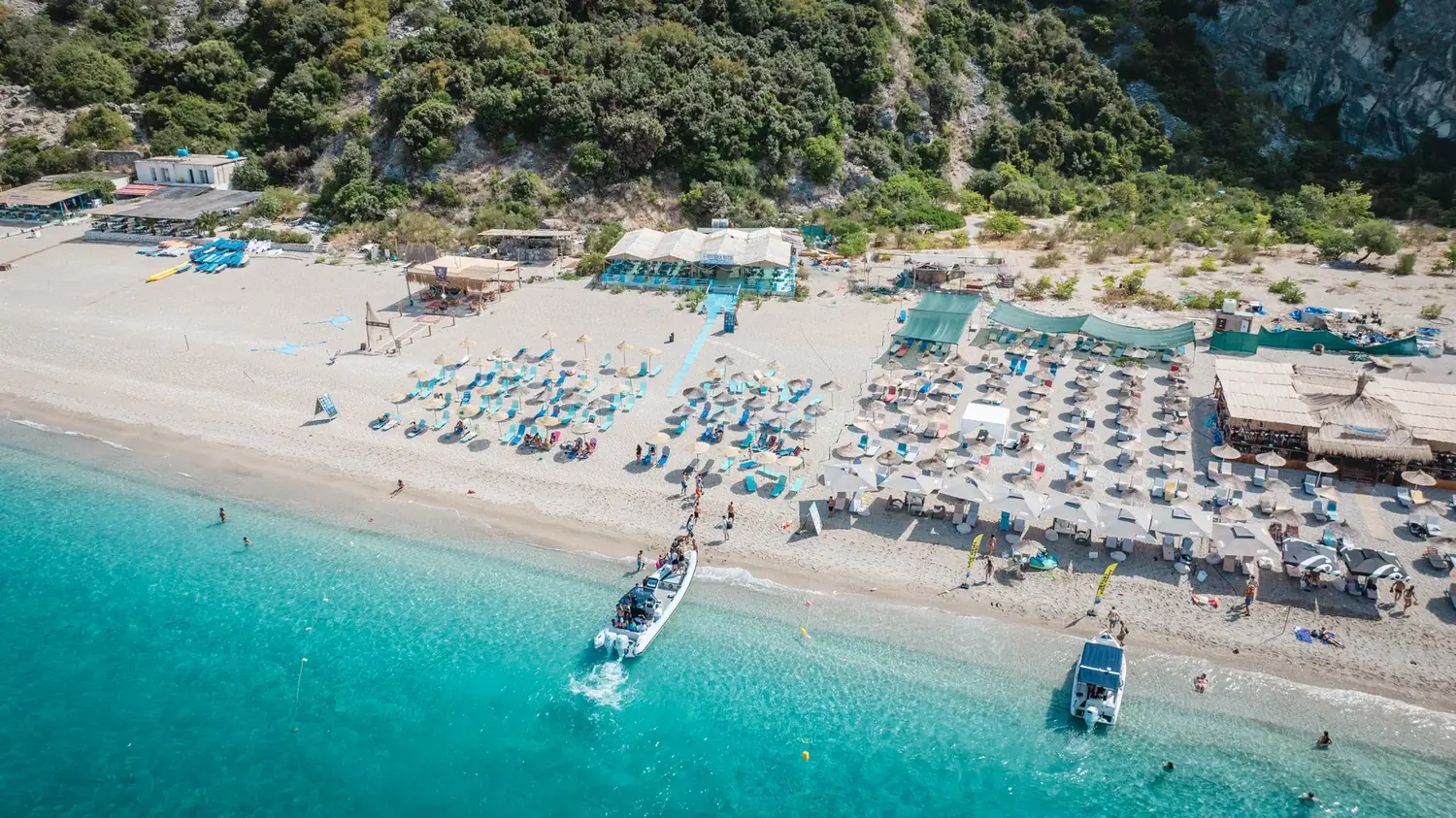 Aerial drone view of a long white-sand Albanian Riviera beach with turquoise water