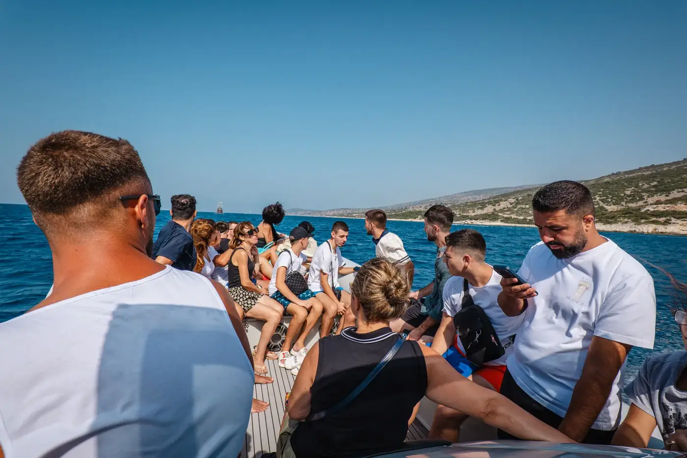 Guests seated along both tubes of the Beast Boat while it cruises the coast near Saranda